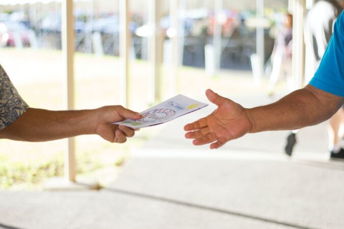 passing a marketing leaflet between two people.