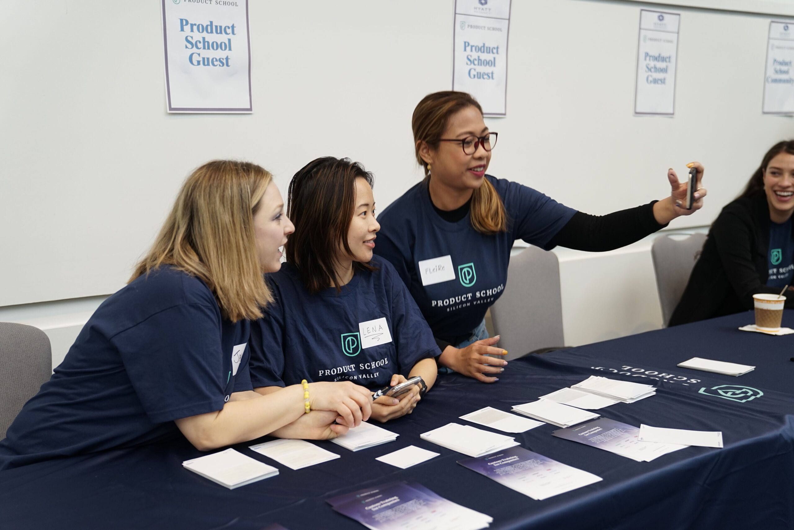 three women on a stall at a trade show.