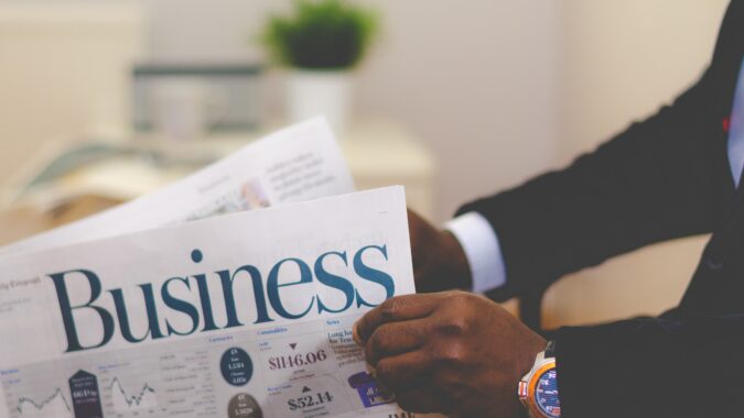 man reading business section of newspaper.