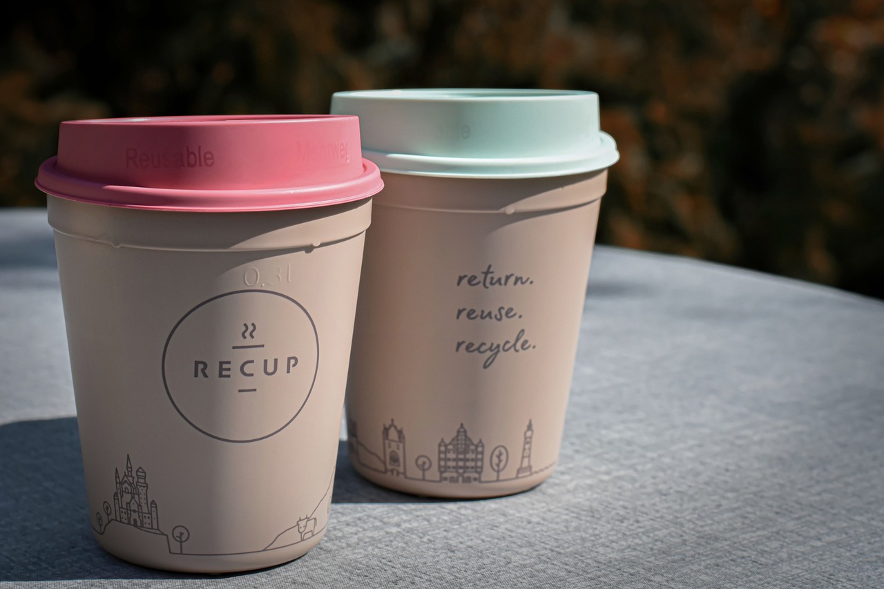 two reusable coffee cups on a table.