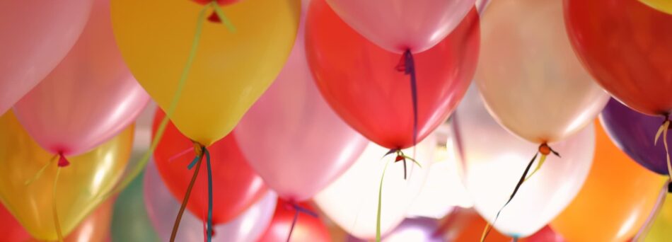 multi-coloured balloons floating towards ceiling.