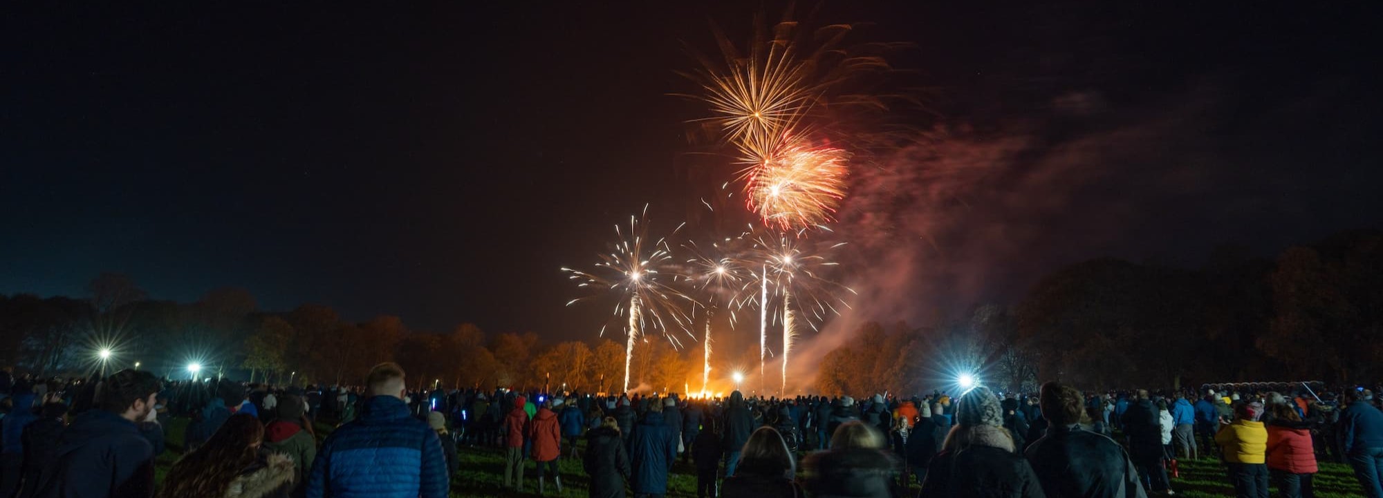 people watching public bonfire and fireworks.