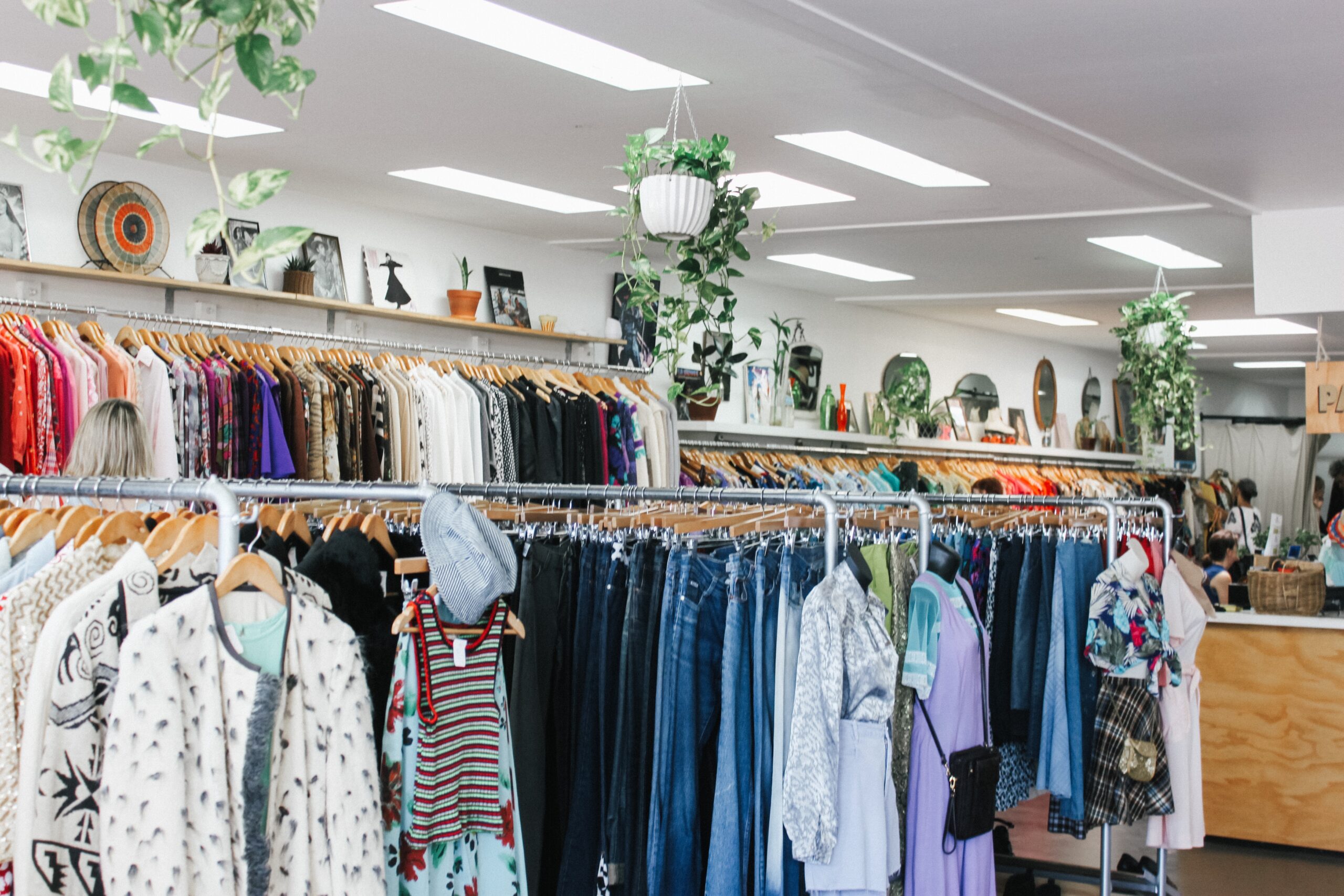 clothes on rails inside a charity shop.