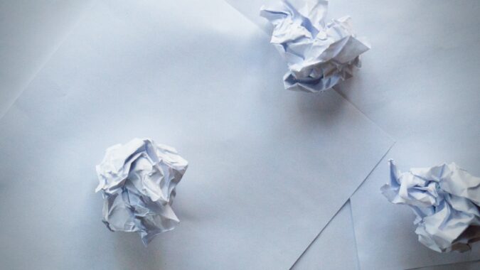 three balls of scrunched up paper on a sheet of paper.