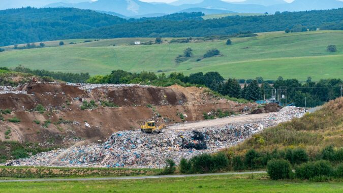 landfill site surrounded by green fields and hills.