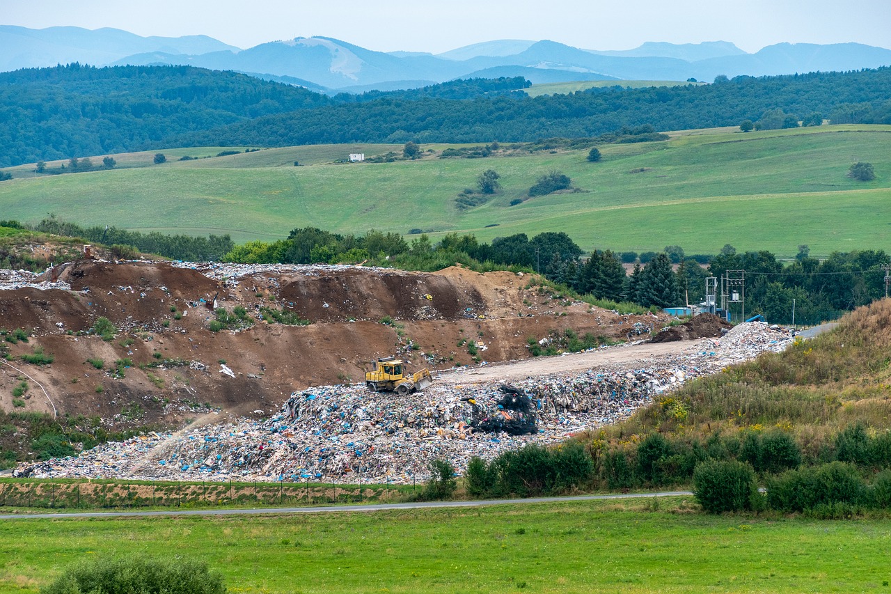 landfill site surrounded by green fields and hills.
